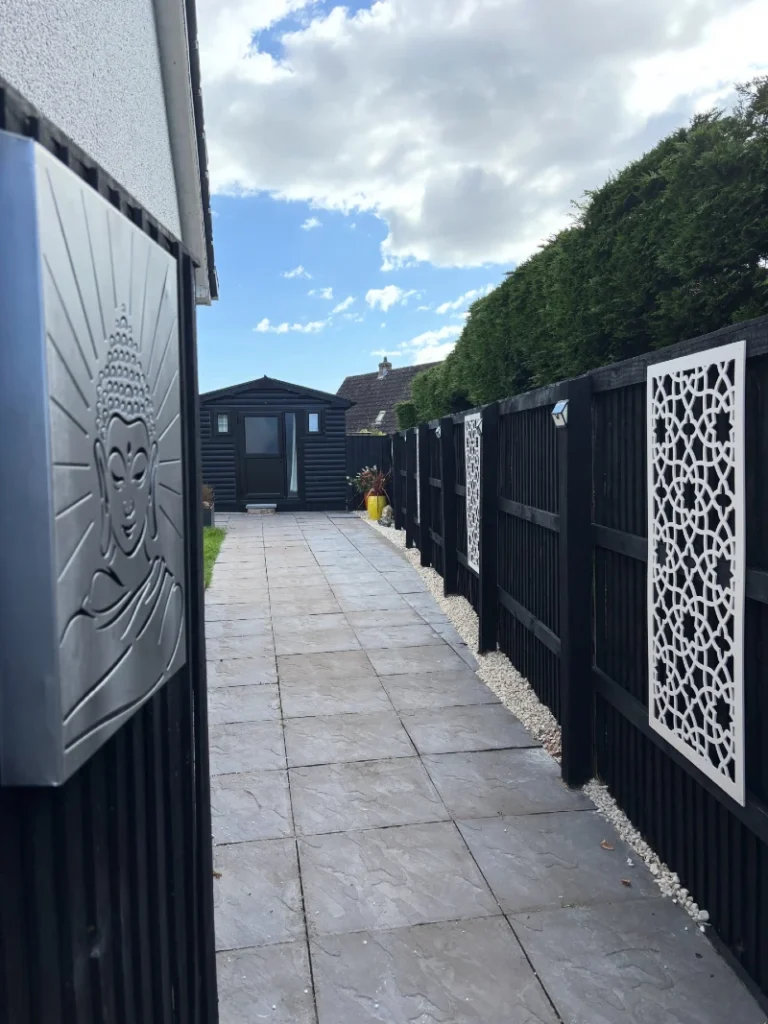 1. Black Fence with White Cutout Panels and Solar Wall Lights