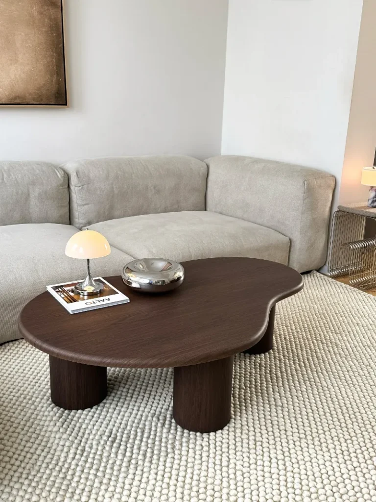 1. Kidney Shaped Dark Wood Coffee Table with Cream Sofa and Pebbled Wool Rug