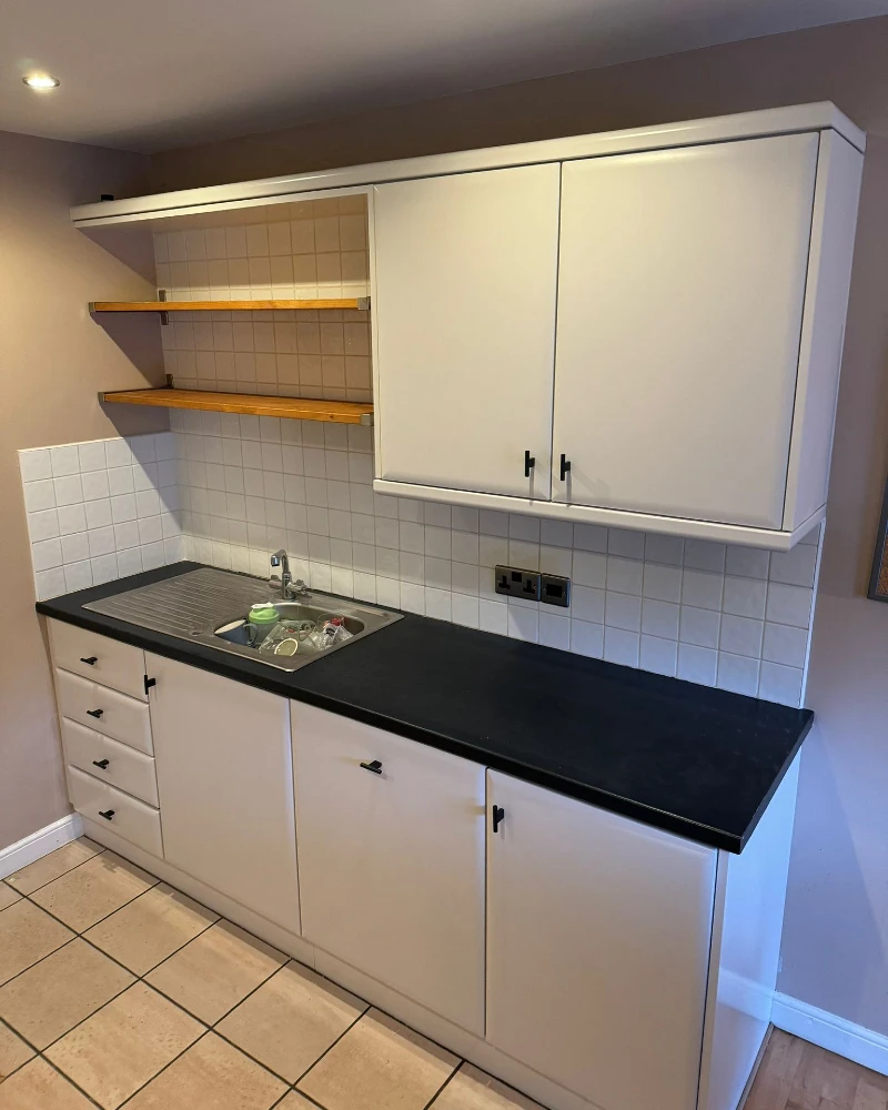 1. Matte White Cabinets with Open Wooden Shelves and Black Countertop Contrast