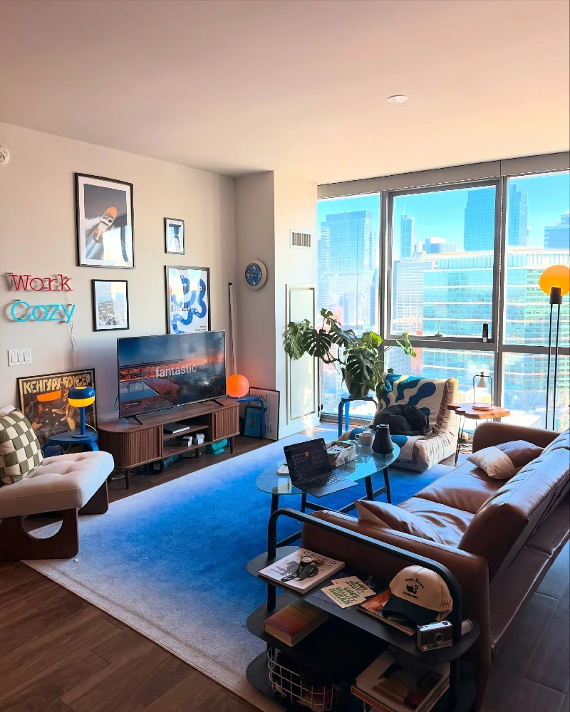 10. Blue Rug Apartment Living Room with Brown Leather Sofa and City View