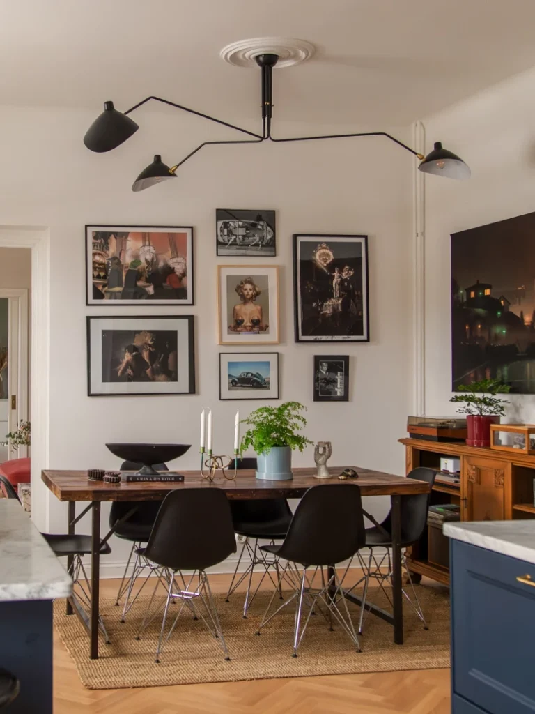 10. Dining Room Gallery Wall with Mixed Photography Above Wooden Table and Sculptural Lighting