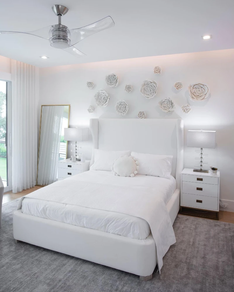 10. White Wingback Bed with Sculptural Flower Wall and Gold Framed Mirror