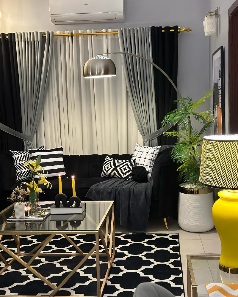 11. Black Velvet Sofa with Gold Glass Coffee Table and Yellow Accent Lamp