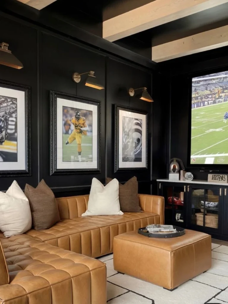 11. Camel Leather Sectional with Sports Art and Black Paneled Walls