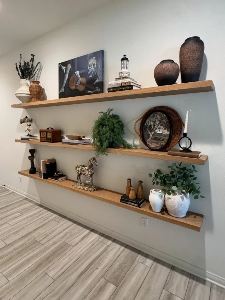 11. Long Wood Gallery Shelves with Moody Art, Vintage Objects, and Speckled Pottery