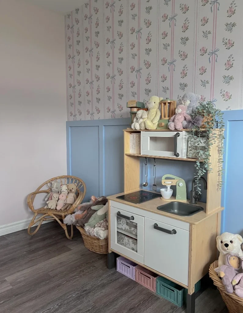 11. Soft Pastel Play Kitchen Corner with Floral Wallpaper and Rattan Seating