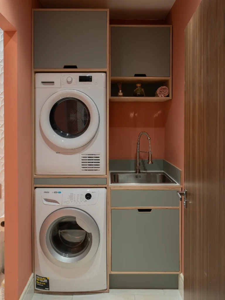 11. Terracotta Laundry Closet with Stacked Machines, Sage Sink Cabinet, and Wood Trim