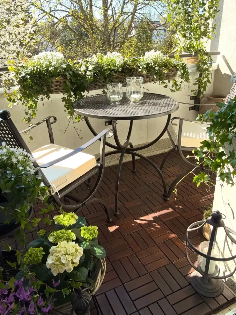 11. Wicker Flower Box Balcony with Metal Bistro Table and Dark Wood Deck Tiles