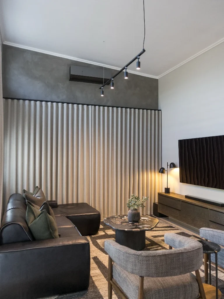 12. Black Leather Sectional with Pleated Curtains and Ripple TV Panel