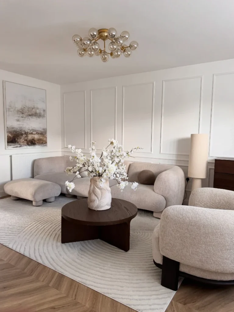 12. Cream Curved Sofa with Dark Wood Coffee Table and White Blossom Branches