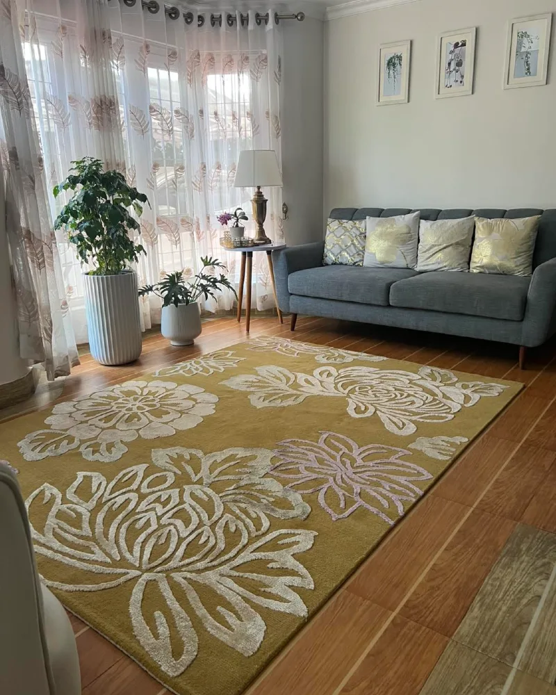 12. Mustard Floral Living Room Rug with Soft Grey Sofa and Warm Sunlit Windows