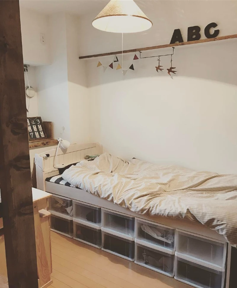 13. Clear Plastic Bins Below a Raised Bed with Striped Bedding and ABC Wall Shelf