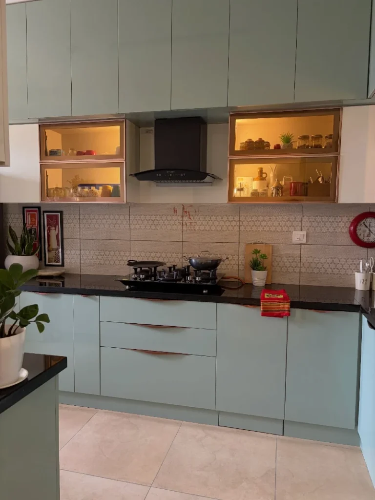 13. Soft Mint Cabinets with Backlit Glass Display Shelves and Patterned Tile Backsplash