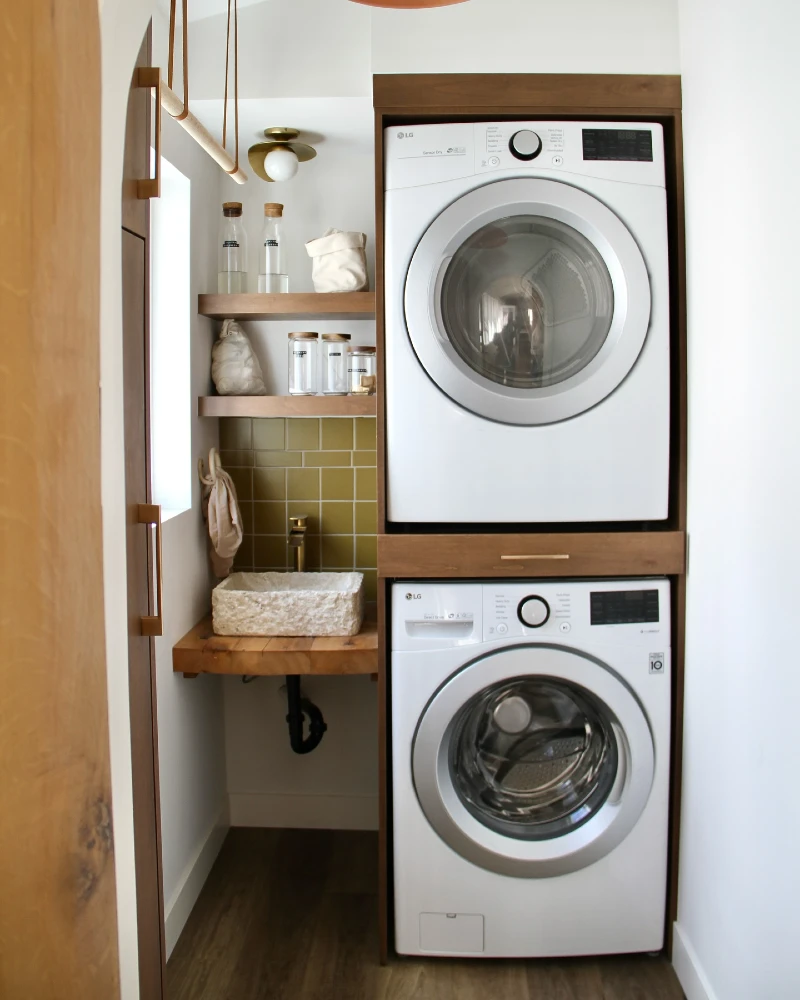 13. Warm Wood Laundry Closet with Stacked Machines, Olive Tile, and Floating Supply Shelves