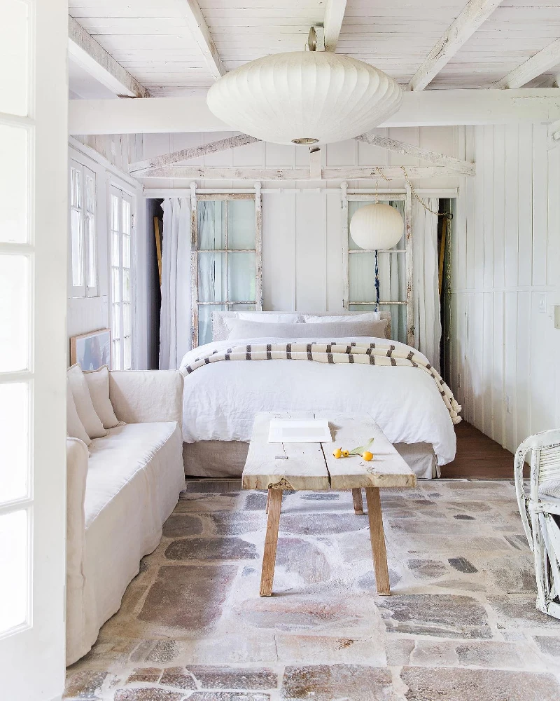 13. Whitewashed Beamed Bedroom with Stone Floor and Raw Wood Bench