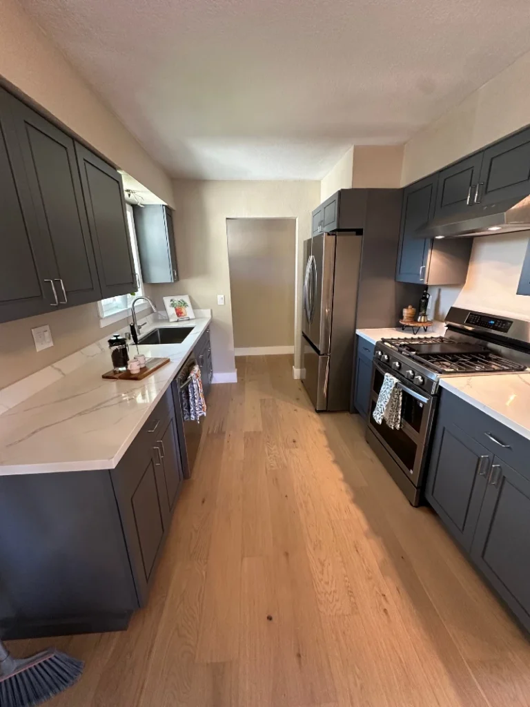 14. Charcoal Galley Kitchen with White Quartz Counters and Pale Oak Flooring