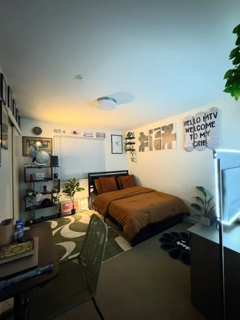 14. Compact Bedroom with Brown Bedding, Skateboard Wall Art, and Open Display Shelf