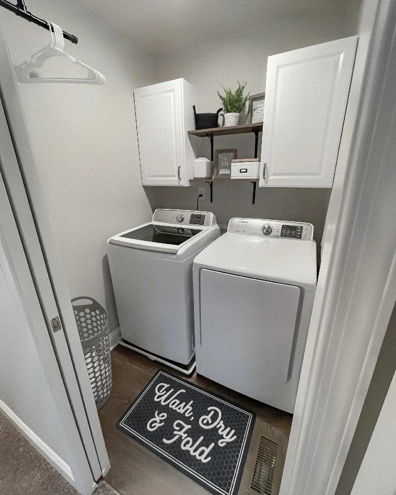 14. Gray Laundry Closet with White Cabinets, Wood Shelves, and Black Hanging Rod