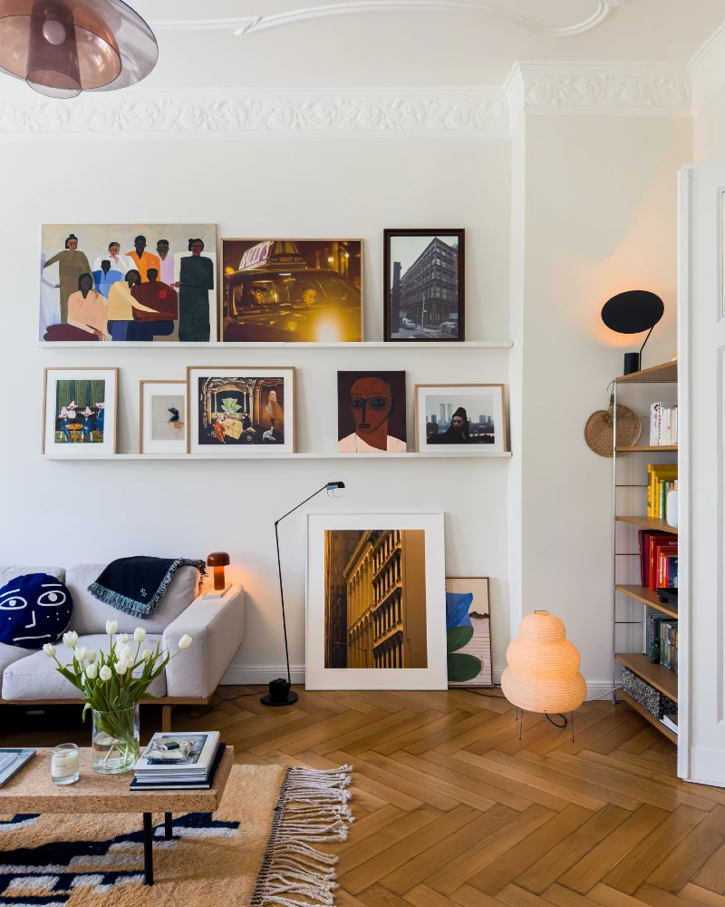 14. Linear Floating Shelf Gallery Wall with Layered Art Above Soft Neutral Sofa