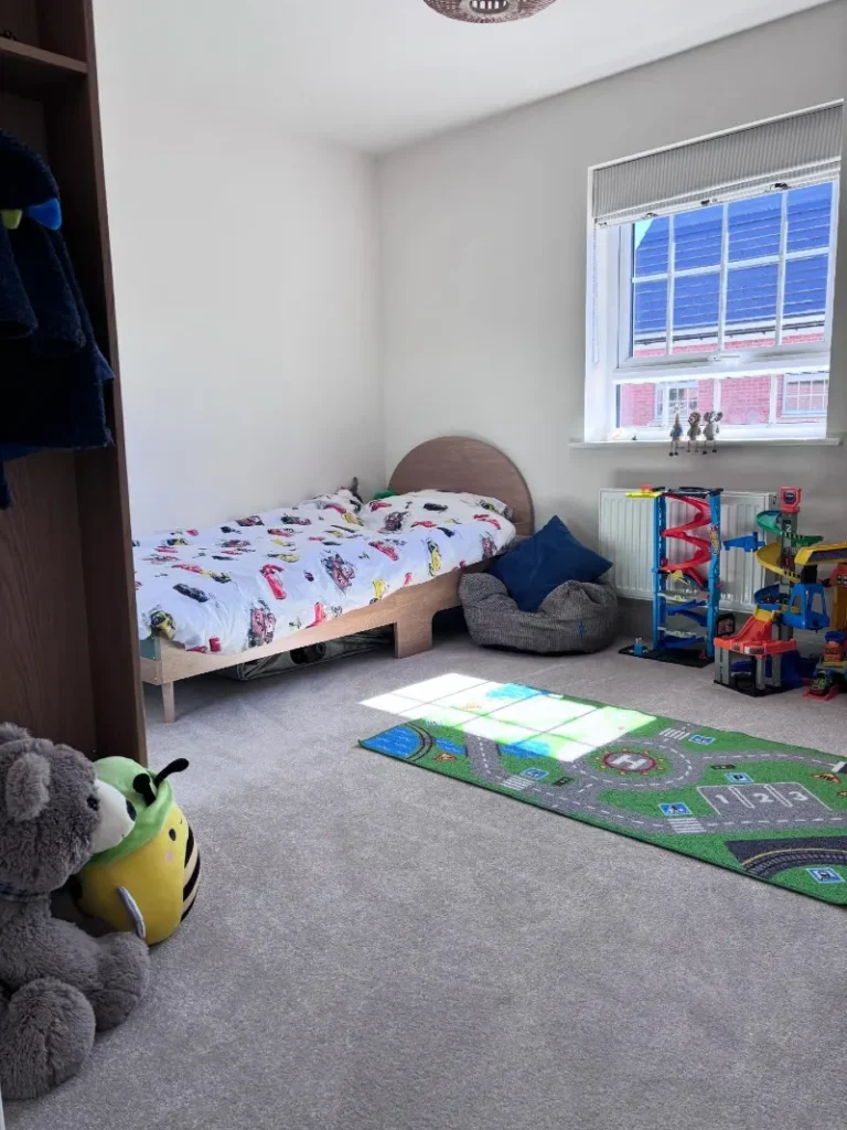 14. Low Wood Bed with Car Bedding, Road Rug, and Open Floor Space