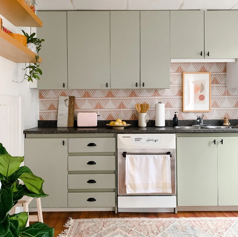 14. Mint Green Cabinets with Pink Geometric Tile Backsplash and Black Counter Contrast
