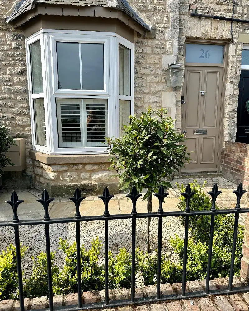 14. Stone Cottage Front Garden with Black Railings, Gravel Bed, and Bay Tree Standard