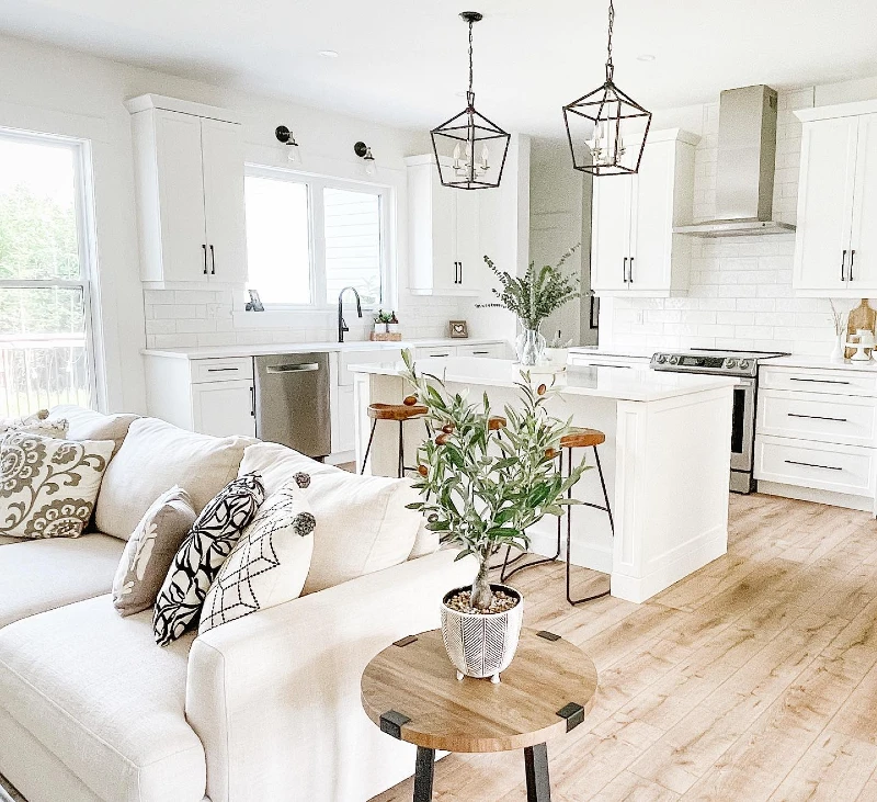 14. White Farmhouse Kitchen with Black Lantern Pendants and Slipcovered Sofa