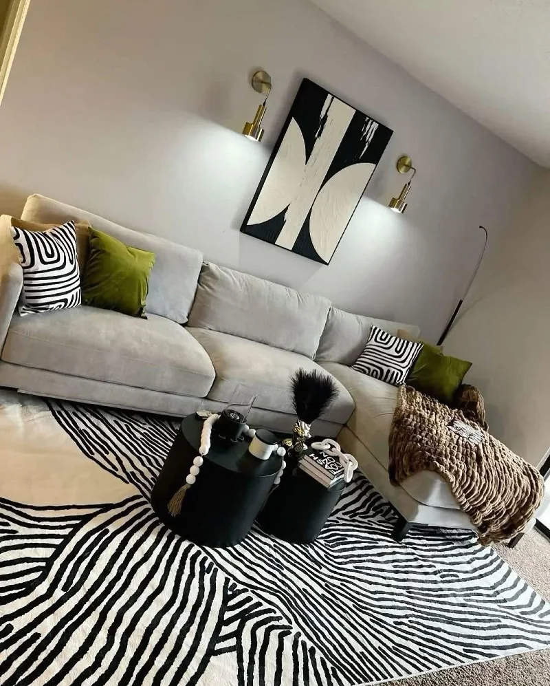 14. Zebra Rug with Cream Sectional, Olive Pillows, and Black Nesting Tables