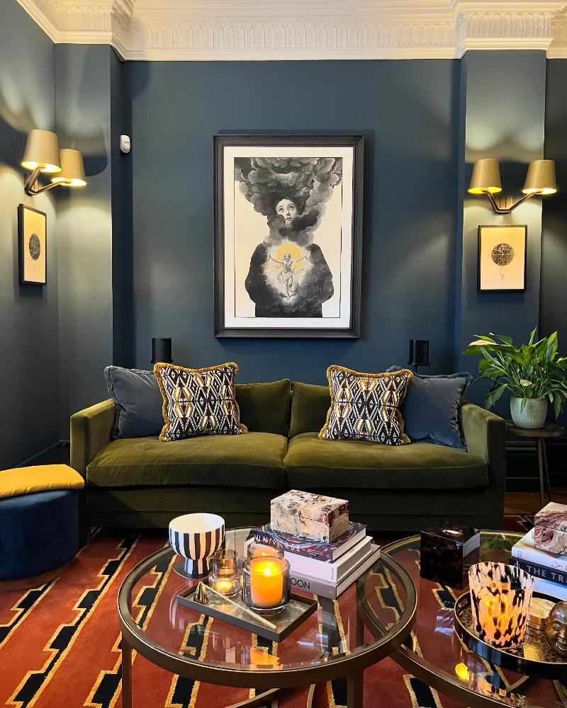 15. Olive Velvet Sofa with Teal Walls, Brass Sconces, and Graphic Rust Rug