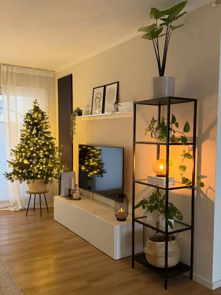 16. Black Metal Plant Shelf with Glowing Orb Lamp and Lit Christmas Tree