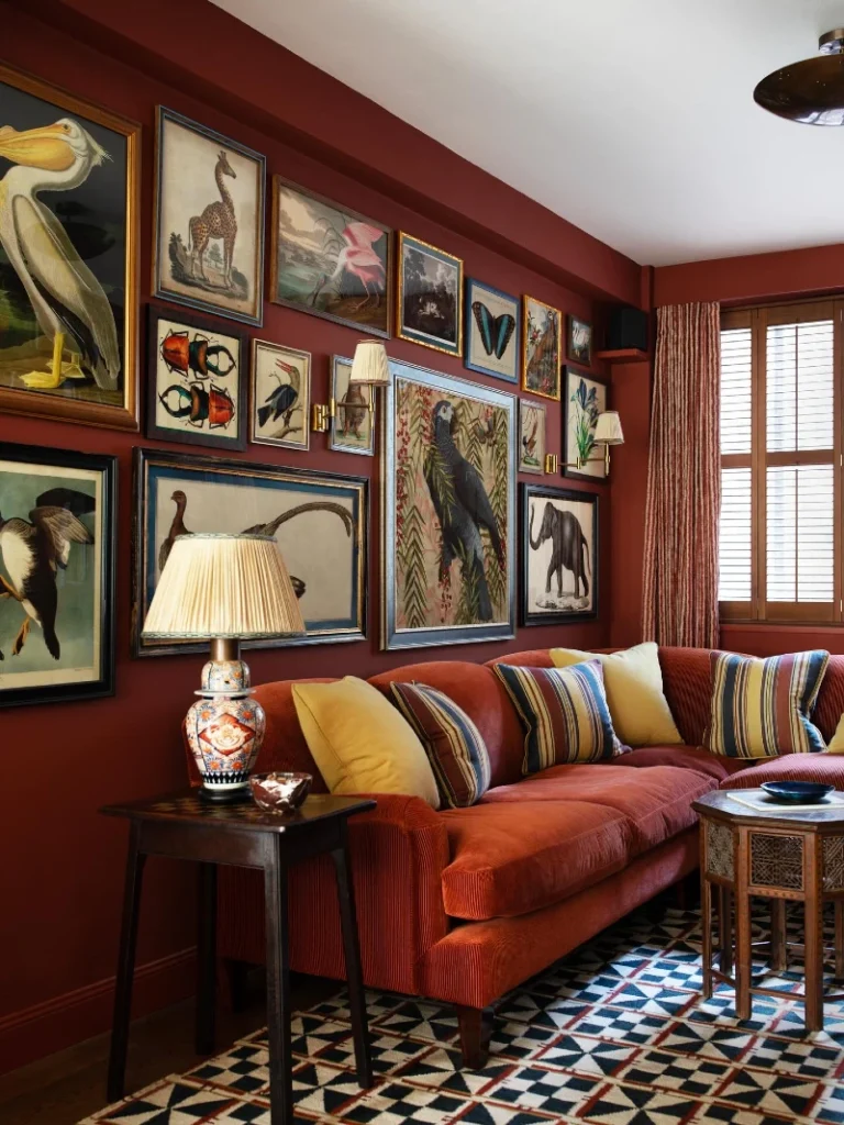 16. Burgundy Accent Wall Gallery with Layered Vintage Animal Prints Above Rust Sofa