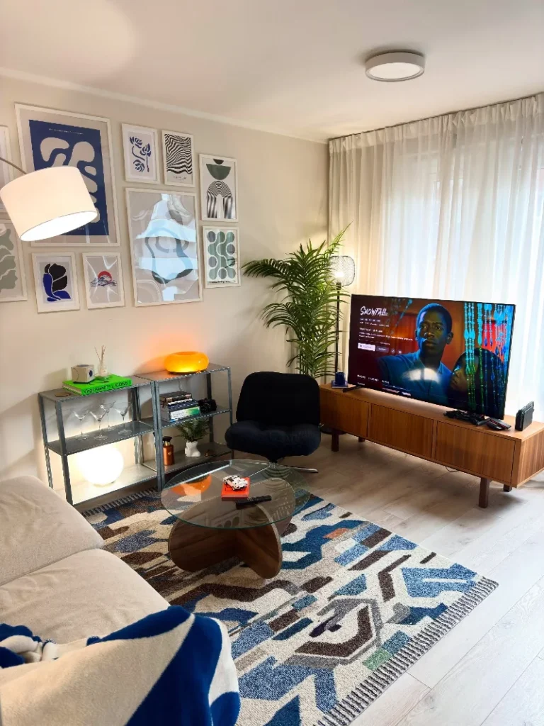 16. Cream Living Room with Abstract Gallery Wall, Glass Table, and Wood TV Console