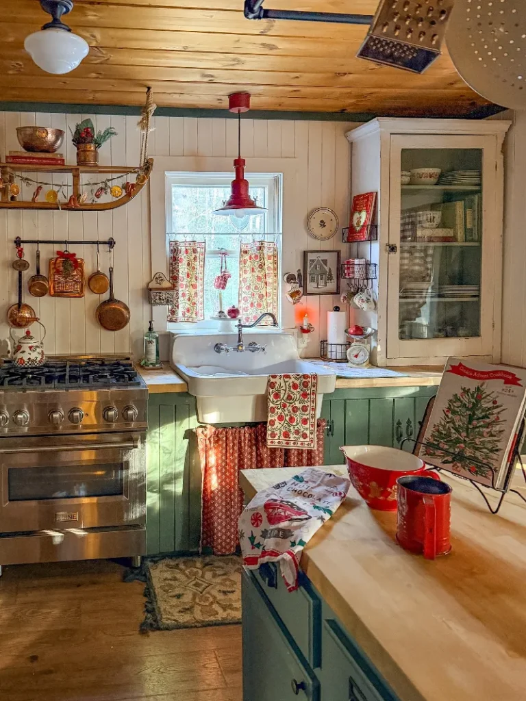 16. Green Cottage Kitchen with Copper Pans, Red Pendant, and Holiday Textiles