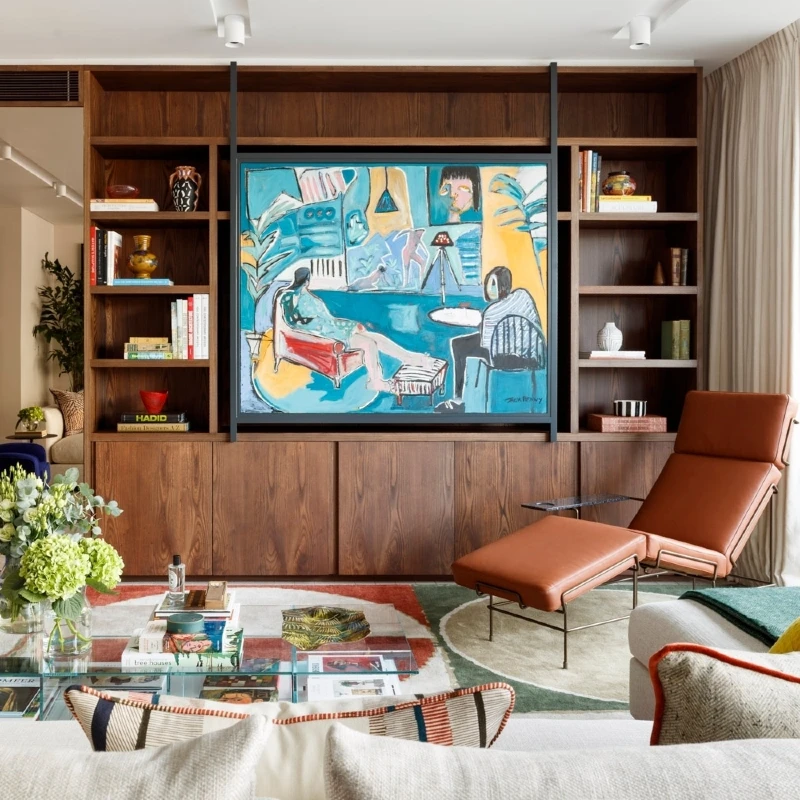 16. Walnut Shelf Wall with Colorful Art, Cognac Lounge Chair, and Glass Coffee Table