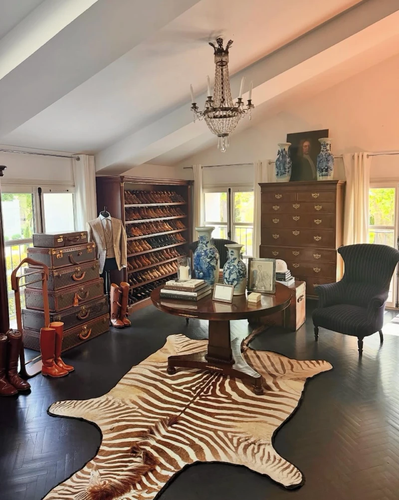 16. Zebra Hide Rug with Shoe Cabinet, Stacked Trunks, and Blue Ceramic Vases