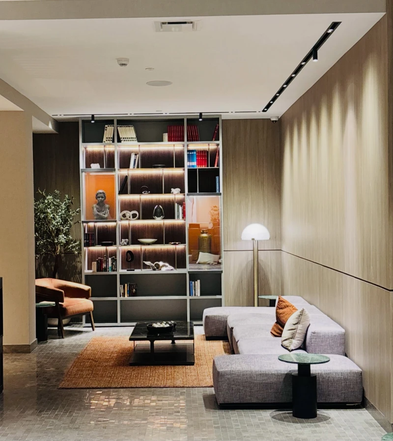 17. Backlit Library Wall with Wood Paneling, Gray Sectional, and Rust Accent Chair