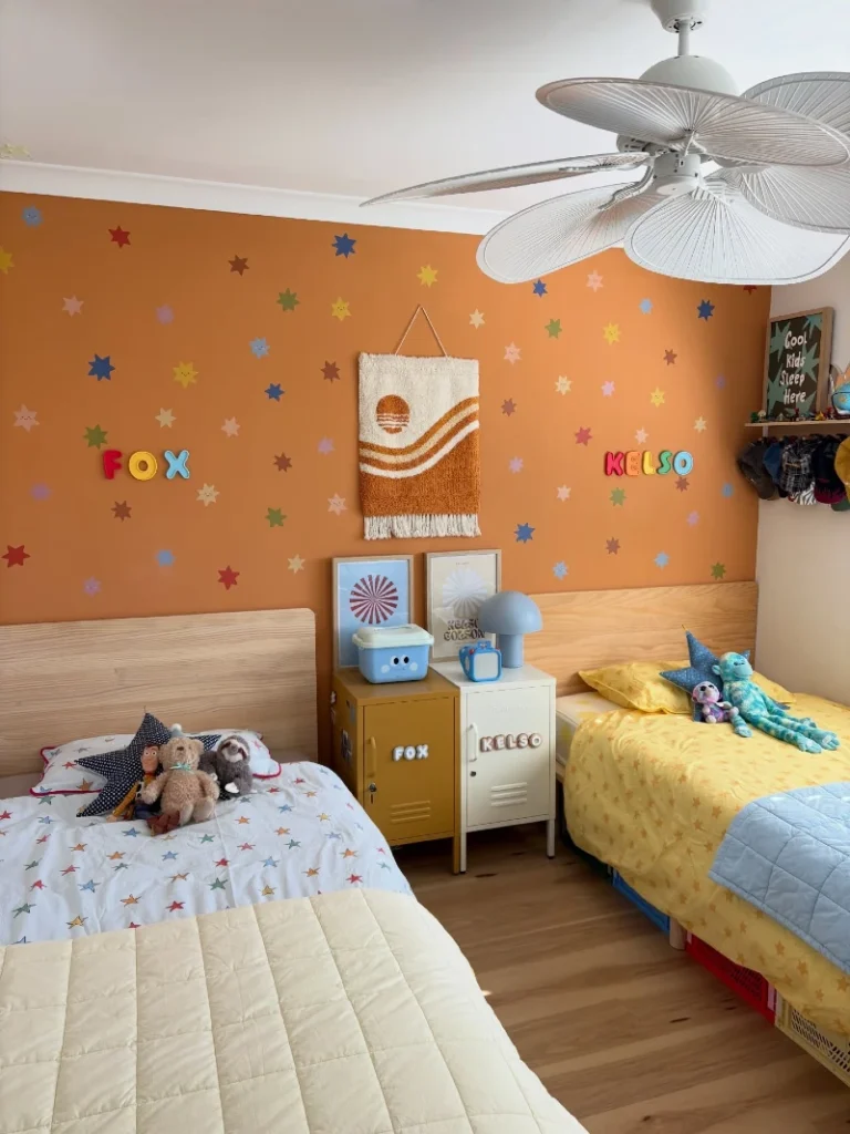 17. Burnt Orange Star Wall with Twin Beds, Locker Nightstands, and Leaf Fan