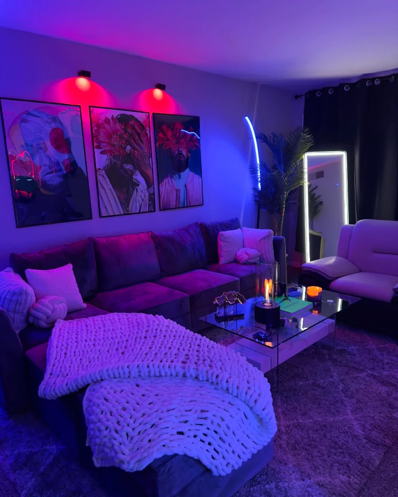 17. Purple Lounge with Floral Portrait Prints, Chunky Knit Throw, and Glass Coffee Table