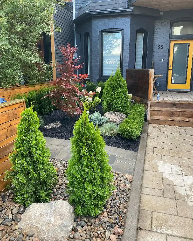 17. Urban Front Garden with River Rock, Cone Evergreens, and a Yellow Door