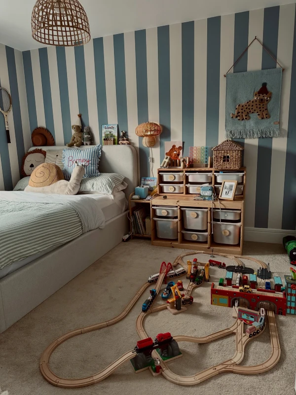 18. Blue Striped Bedroom with Wooden Train Track, Toy Storage, and Woven Lights