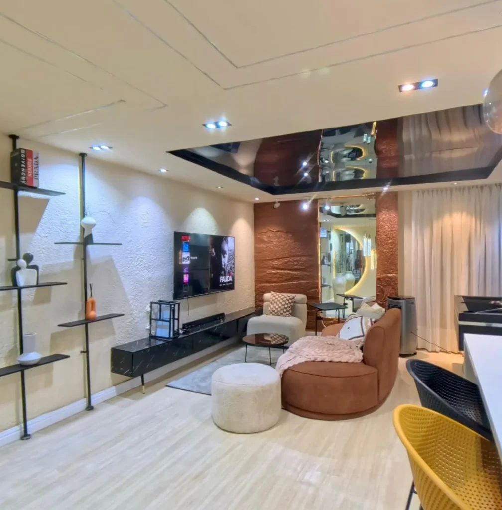 18. Textured TV Wall with Caramel Curved Sofa, Black Pipe Shelves, and Glossy Ceiling Panel