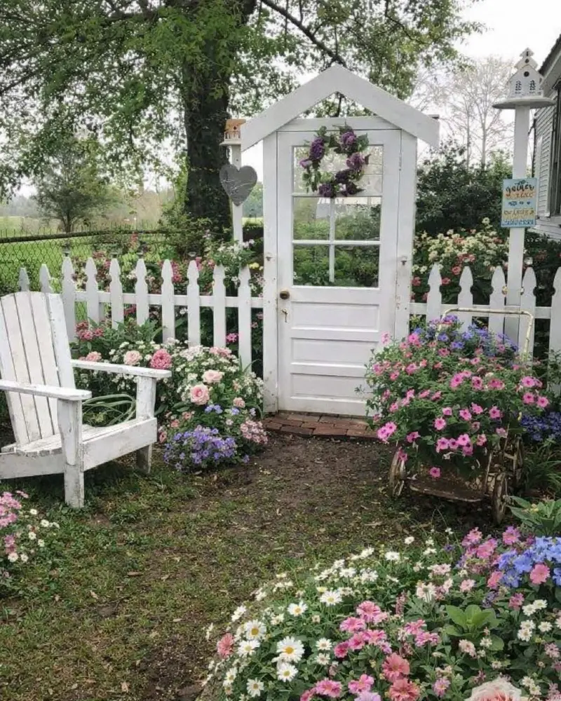 18. White Picket Fence with Door Gate, Purple Wreath, and Cottage Flower Beds