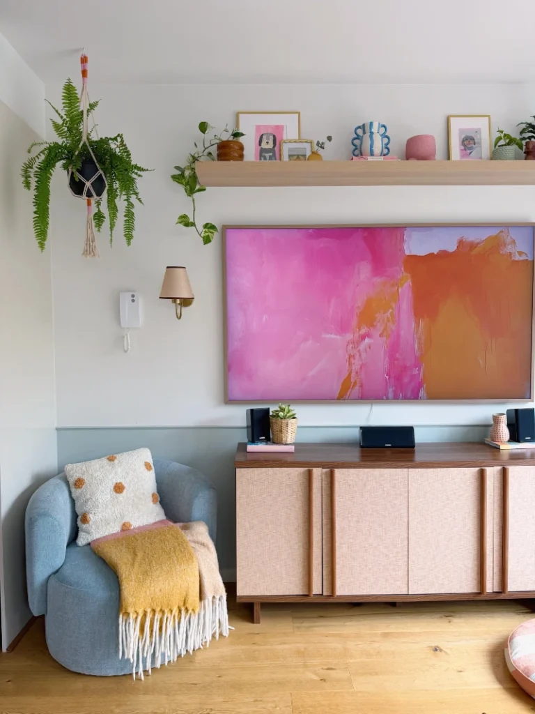 19. Colorful Media Wall Shelf with Pink Art, Playful Planters, and Hanging Fern