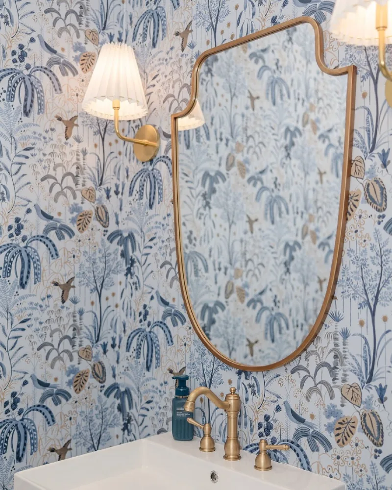 2. Blue Toile Wallpaper Vanity with Brass Sconces and Soft Gold Mirror Frame
