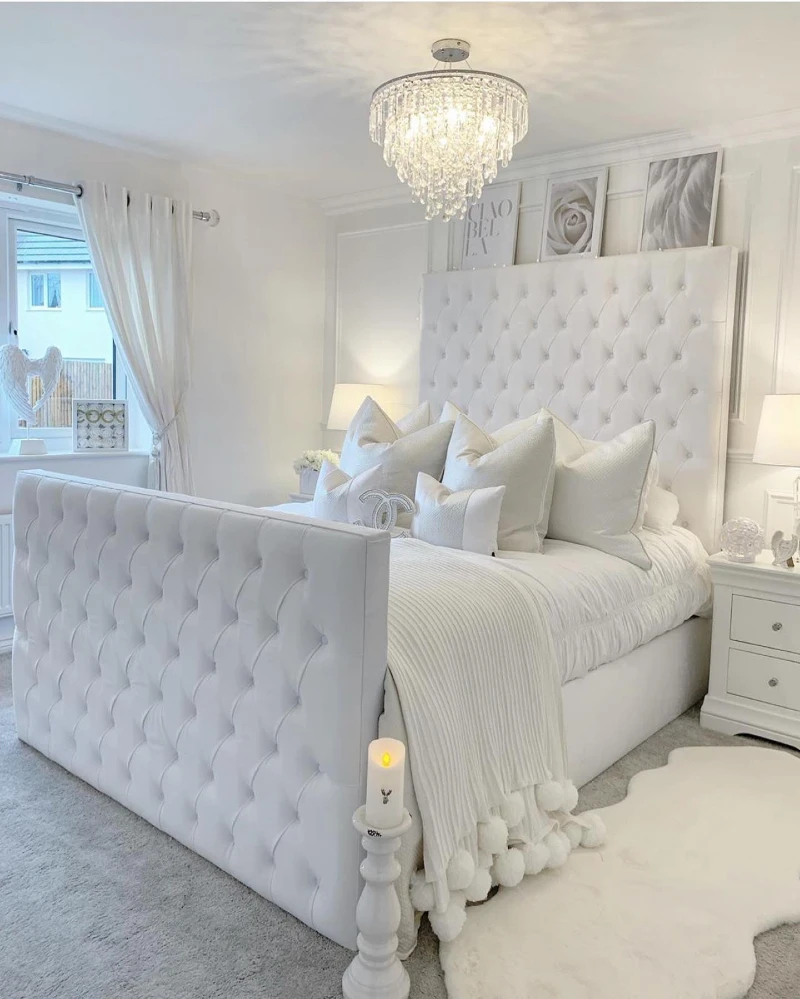 2. Tufted White Bed with Crystal Chandelier and Pom Pom Throw