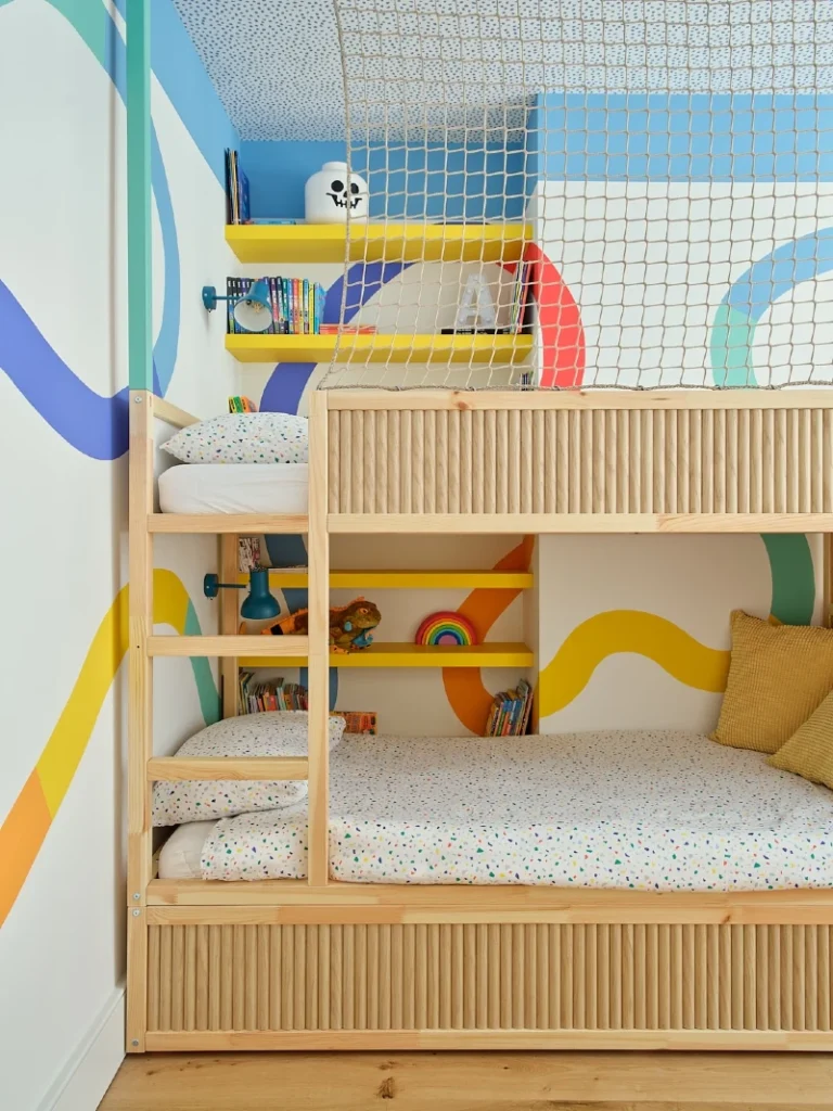 21. Light Wood Bunk Bed with Safety Net, Yellow Shelves, and Ribbon Wall Mural