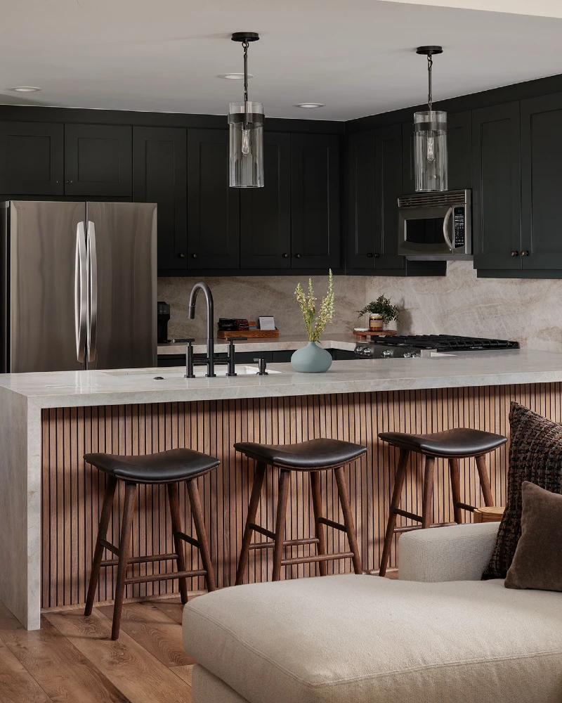 3. Matte Black Cabinets with Wood Slat Island and Glass Pendant Lighting