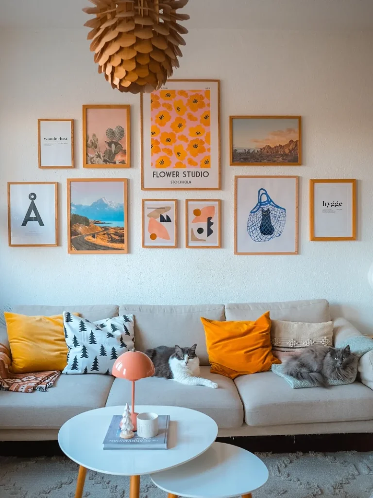 3. Mid-Century Orange Gallery Wall with Warm Minimal Frames Above Neutral Sofa