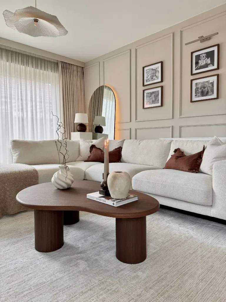 3. Rounded Dark Wood Coffee Table with Cream Sectional and Rust Velvet Pillows