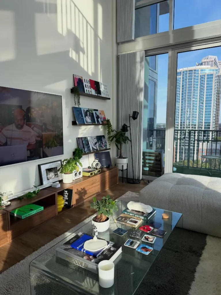 3. Sunlit High Rise Lounge with Record Shelves, Wood Cabinets, and Glass Coffee Table